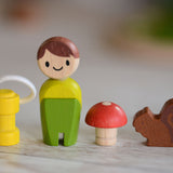 A line up of the lamp, doll, toadstool and squirrel pieces that come with the PlanToys PlanWorld tree house set.