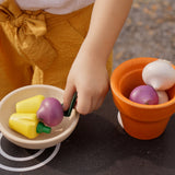 Plan Toys wooden play food Produce Set containing Radish, Garlic & Yellow Peppers. The produce has been placed in a wooden pot and a wooden bowl.