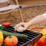 A child placing a toy wooden onion from the Plan Toys Vegetable Produce Set on a metal grill.