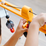 A close up of a child playing with the PlanToys PlanWorld Crane Set, the child is operating the crane.
