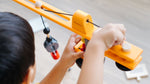 A close up of a child playing with the PlanToys PlanWorld Crane Set, the child is operating the crane.
