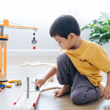 A child playing with the PlanToys PlanWorld Crane Set.