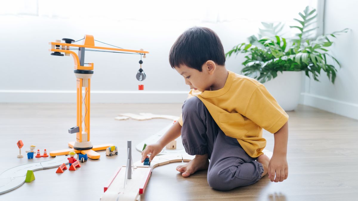 A child playing with the PlanToys PlanWorld Crane Set.