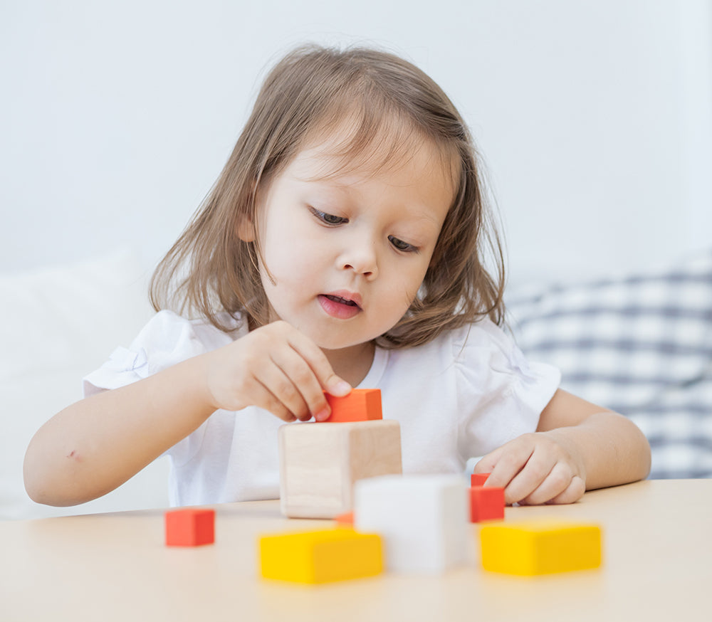 A child playing with the PlanToys Fractions Cubes.