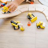 A close up of a child playing with the PlanToys Road Construction Set.