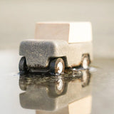 Close up of Plan Toys Wagon car in a puddle.