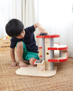 A child playing with the PlanToys PlanWorld Parking Garage.