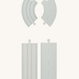 Some pieces from the PlanToys Rubber Road and Rail Extension Pack on a plain background showing both the road and rail sides.