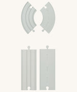 Some pieces from the PlanToys Rubber Road and Rail Extension Pack on a plain background showing both the road and rail sides.