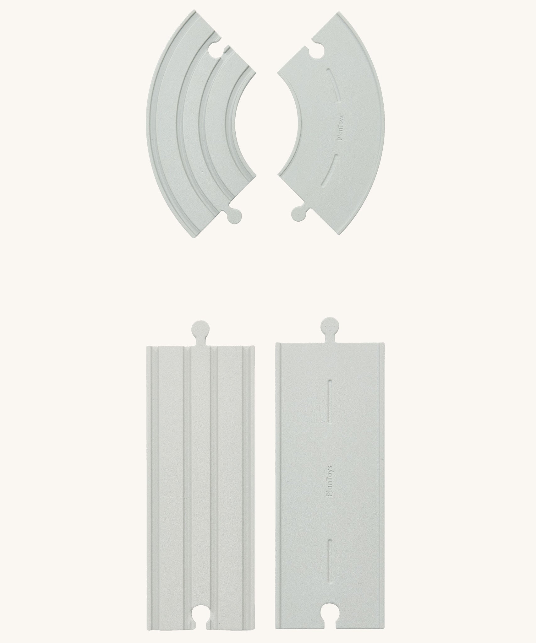 Some pieces from the PlanToys Rubber Road and Rail Extension Pack on a plain background showing both the road and rail sides.