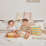 2 children sat on the floor playing with the PlanToys plastic-free wooden musical toys