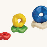 The pieces from the Plan Toys wooden Wave Stacker placed on top of each other.