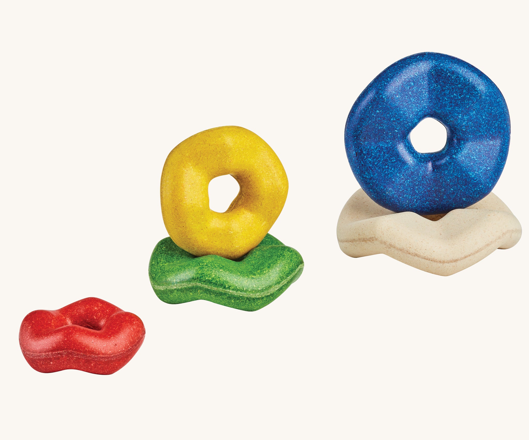 The pieces from the Plan Toys wooden Wave Stacker placed on top of each other.