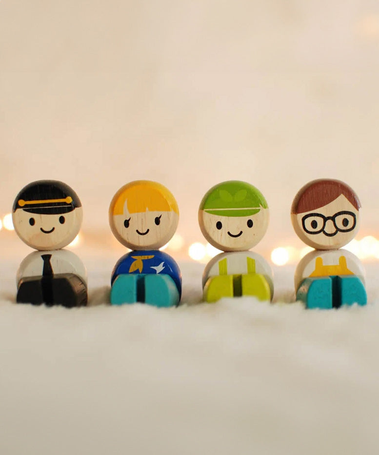 The PlanToys Service Crew figures shown in the sitting position on a fluffy service, fairy lights can be seen in the background.