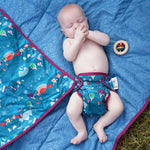 baby wearing the Babipur exclusive dan y ser print close pop-in nappy on a playmat