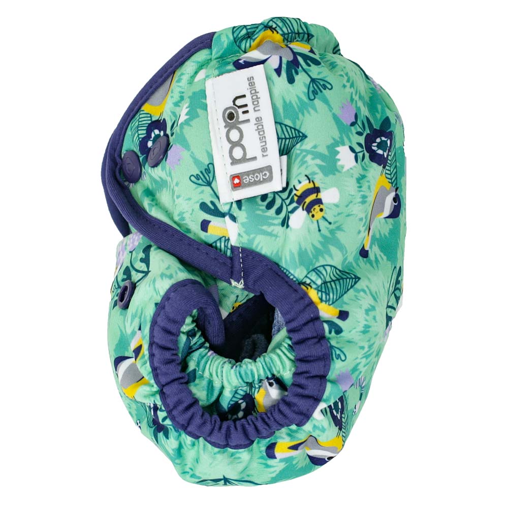 A side view of the Close Pop-In +bamboo reusable cloth nappy with adjustable popper closures, in a round the garden print