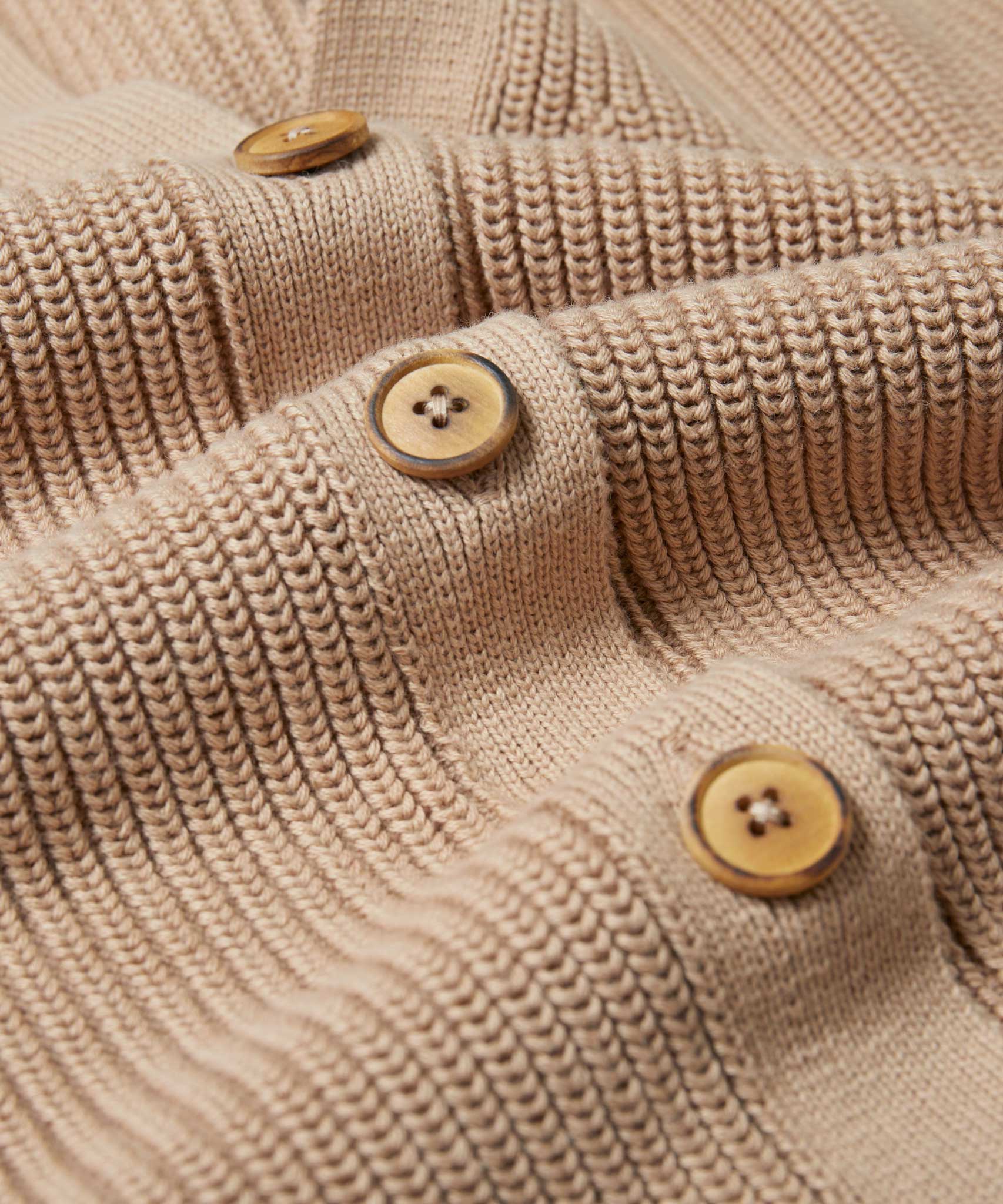 A close up of the wooden buttons on the Rapanui Brook Organic Cotton Women's Knitted Cardigan.