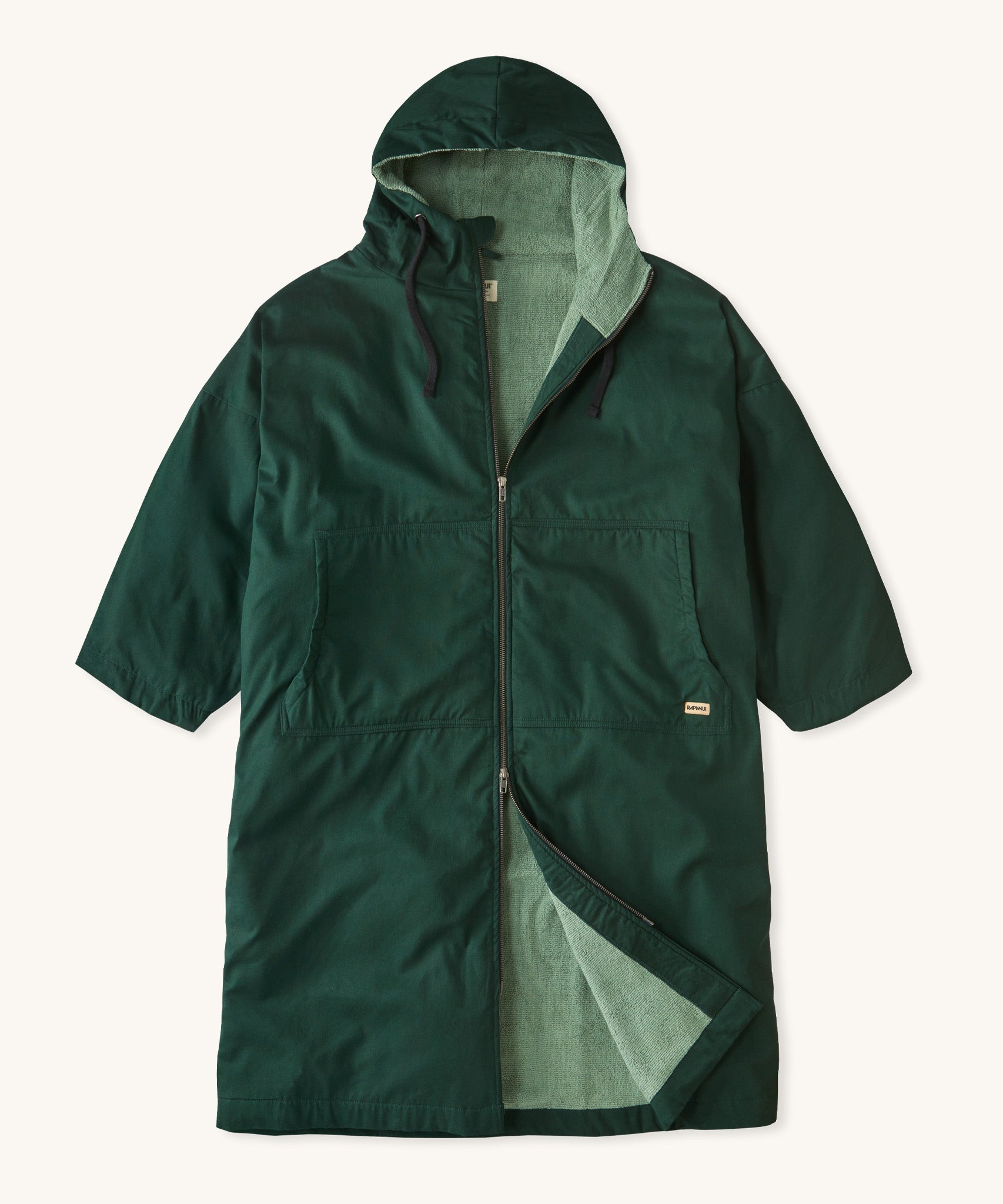 Rapanui changing robe in evergreen colour. A organic cotton long length changing robe with PFC-free water-resistant coating and a towelling lining. Features a two way zip and a hood with pouch pockets.