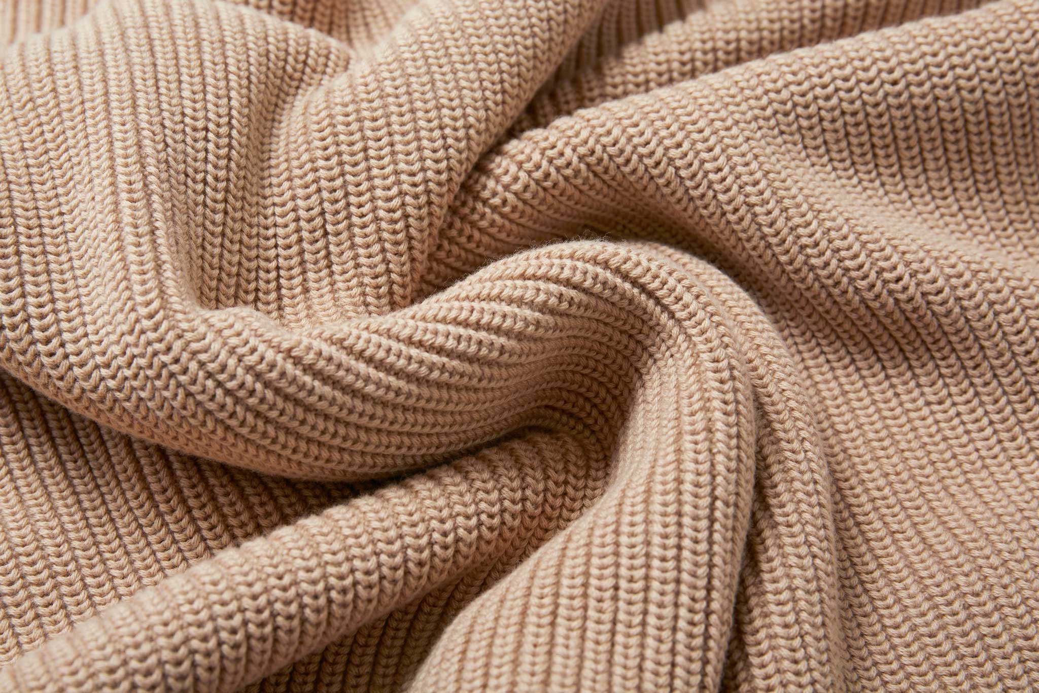 A close up of the material of the Rapanui Brook Organic Cotton Women's Knitted Cardigan. The material has been scrunched together.