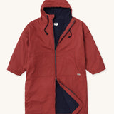 Rapanui changing robe in rust colour. A organic cotton long length changing robe with PFC-free water-resistant coating and a navy towelling lining. Features a two way zip and a hood with pouch pockets.