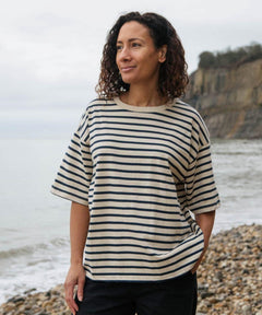 A women wearing the Rapanui oversized striped t-shirt. A organic cotton top in neutral and navy stripe with a neutral neck trim