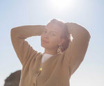 A woman wearing the Rapanui Brook Organic Cotton Women's Knitted Cardigan.