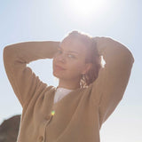 A woman wearing the Rapanui Brook Organic Cotton Women's Knitted Cardigan.