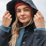A close up of the women's Rapanui maritime line coat showing the hood and popper fastener detail