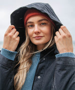 A close up of the women's Rapanui maritime line coat showing the hood and popper fastener detail