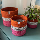 Respiin jute fire zig zag basket set standing upright on a drawer in a bedroom with a plant in the smallest basket