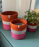 Respiin jute fire zig zag basket set standing upright on a drawer in a bedroom with a plant in the smallest basket