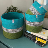 Respiin jute ocean zig zag basket set standing upright on a drawer in a bedroom with a smaller and middle basket standing on top of books