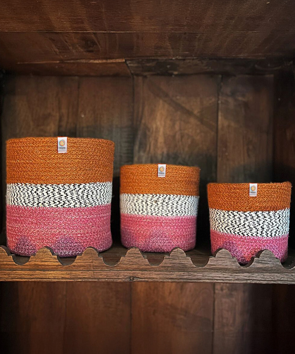 A row of the fire Respiin just fire zig zag baskets standing upright on top of a vintage wooden shelf