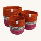 Respiin jute zig zag basket in fire. 3 different sized basket that can fit inside each other. Each basket is  vibrant orange on the top, dark pink on the bottom with a black and white pattern through the middle.