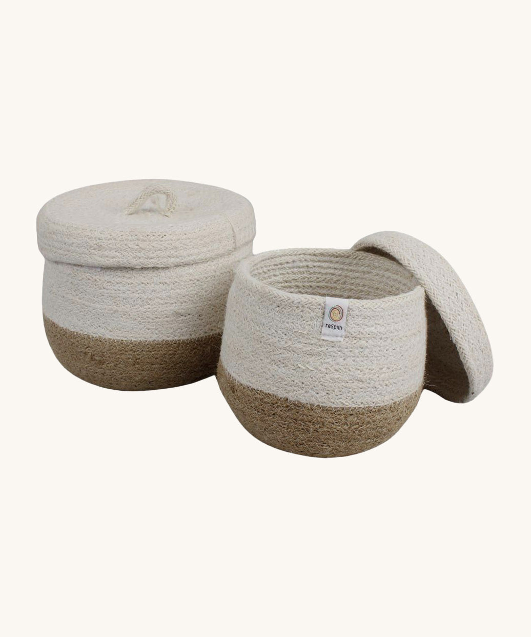 Respiin natural jute lidded basket set. A set of 2 white and natural baskets with matching white lids. Features a little handle on top for easy opening
