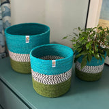 Respiin jute ocean zig zag basket set standing upright on a drawer in a bedroom with a plant in the smallest basket