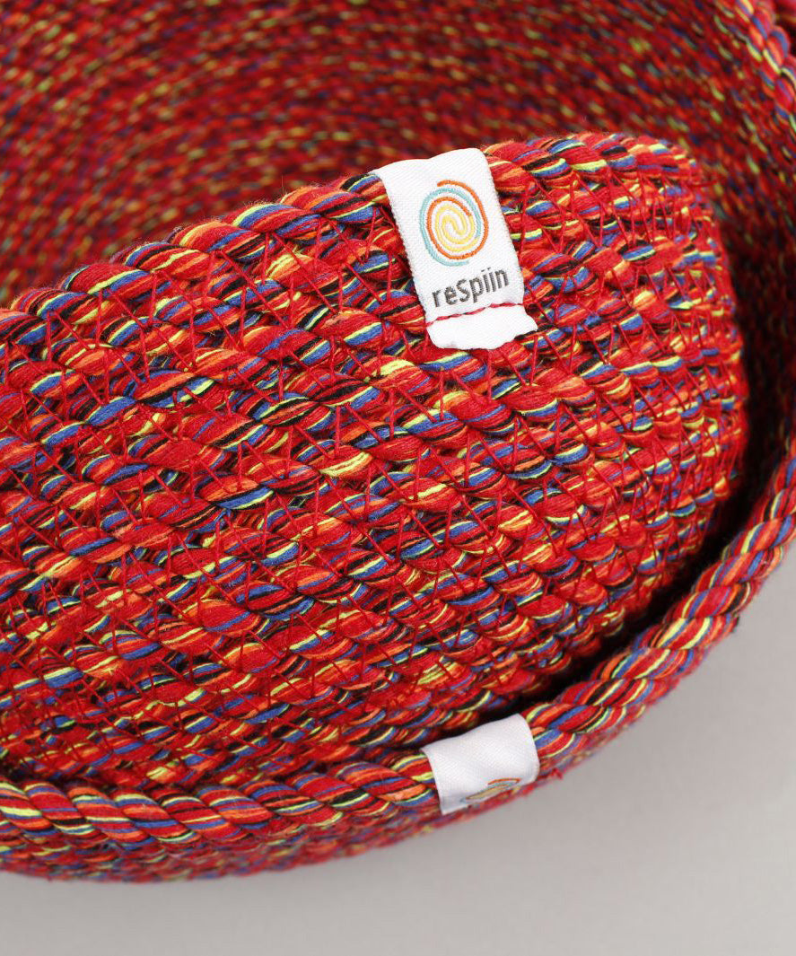 A close up of the 3 Respiin multicoloured recycled cotton bowls showing the weave detail and brand patch stitched on the rim