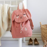 The Roommate Pink Bunny canvas backpack, hanging on a bed frame.