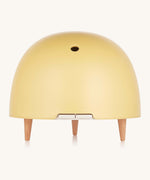 Maël Diffuser, a light yellow dome plug-in essential oil diffuser with wooden feet.