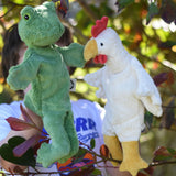 A child playing with the Senger frog and chicken puppets , one on each of their hands.