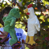 A child playing with the Senger frog and chicken puppets , one on each of their hands.