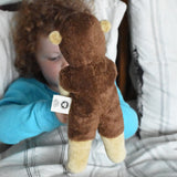 A child holding up the Senger small floppy hedgehog soft toy, a view of the back of the soft toy is shown to camera. The hedgehog is part of a wider selection of soft toys made with organic cotton and natural fillings that are available at Babipur.