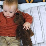 A child holding the Senger brown floppy horse under their arm. This brown horse is from the Senger Floppy collection, a range of soft toy animals made from organic and natural materials.