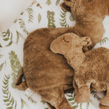 The large and small organic cotton stuffed camel toys on a bed