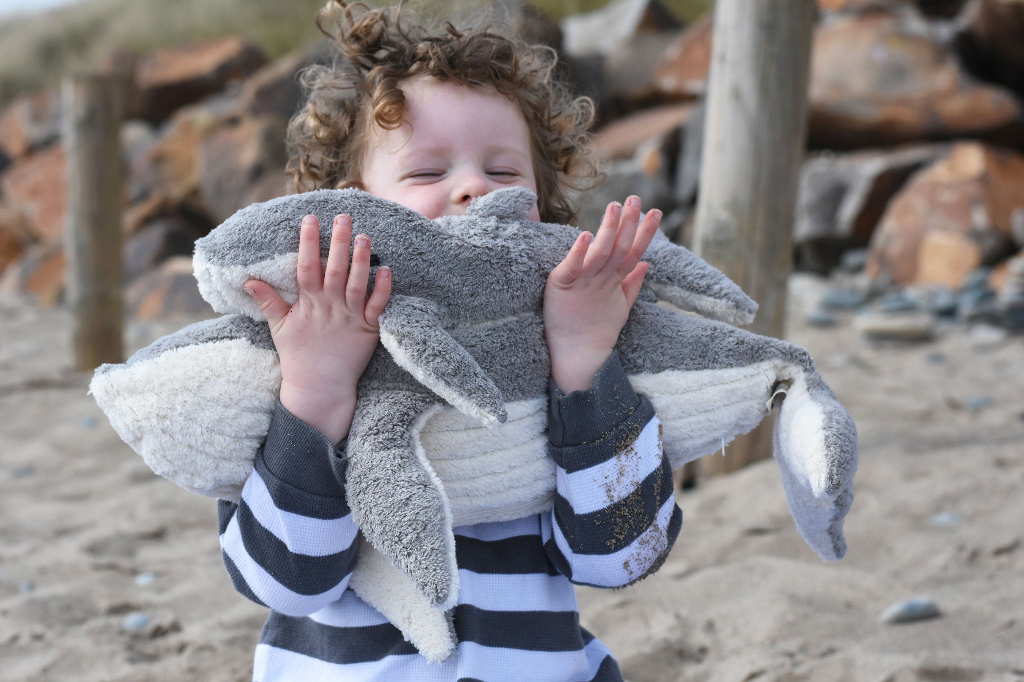 A child holding the large and small Senger cuddly whale animal soft toys.