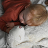 A young child laying down with his head resting on a Senger large white sheep cuddly soft toy. This cuddly sheep is made with organic cotton and natural fillings. This sheep is part of a wide range of soft toys stocked at Babipur.