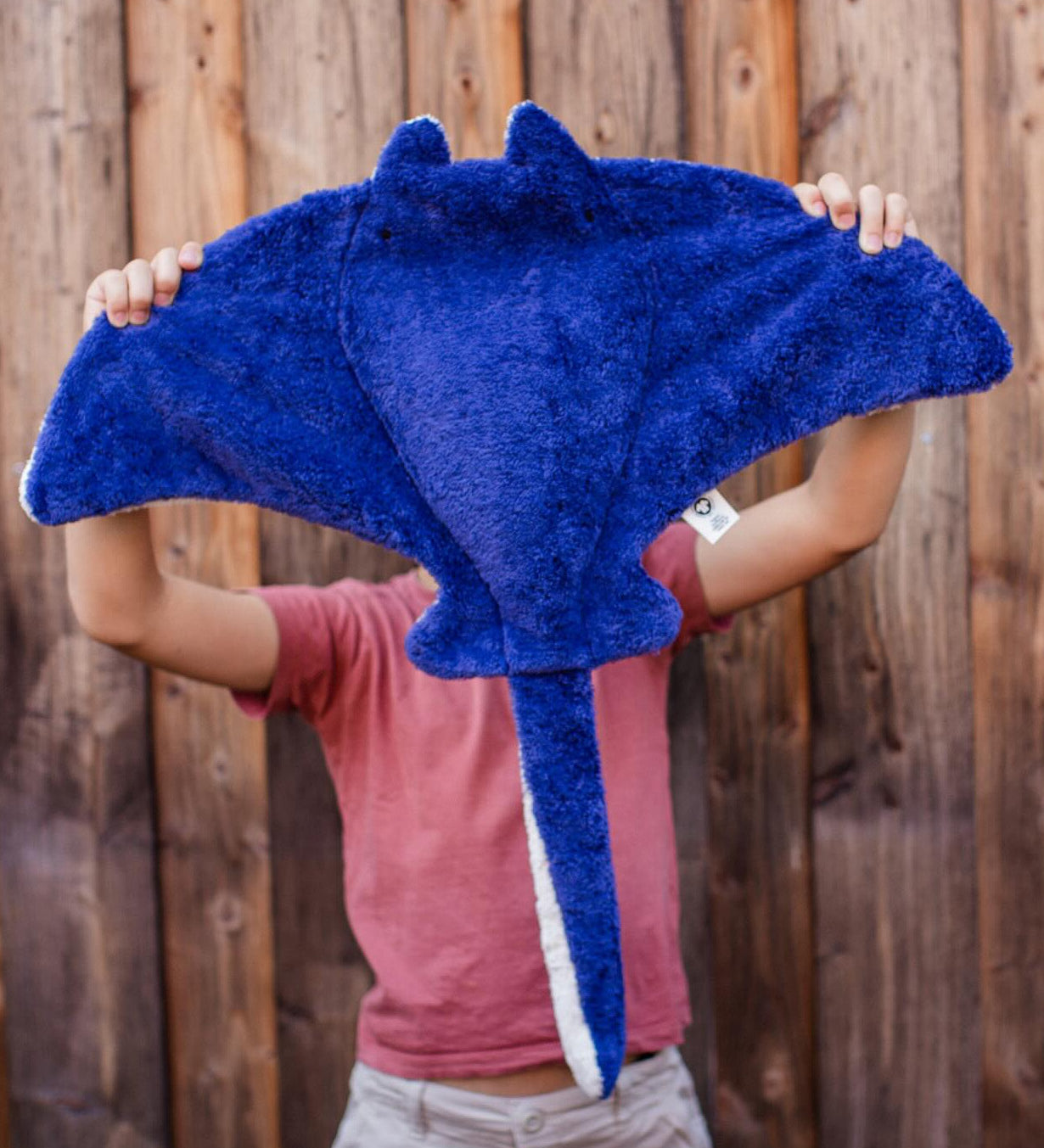 A person holding up the Senger organic cotton stuffed manta ray cuddly toy