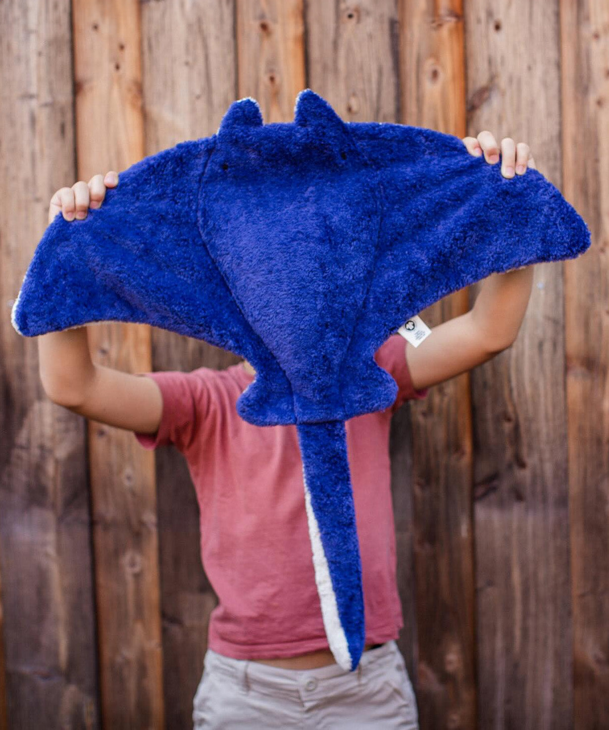 A person holding up the Senger organic cotton stuffed manta ray cuddly toy