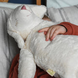 A close up of the Senger large white cuddly sheep soft toy being cuddled by a young child. This sheep is part of a wide range of soft toys made from organic and natural materials stocked at Babipur.