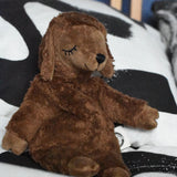 A Senger small brown cuddly sheep organic soft toy placed on a black and white monochrome patterned duvet. The small brown sheep is part of Senger's cuddly range of soft toys available at Babipur.